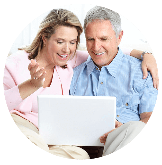 Man and woman smiling while looking at a laptop computer.