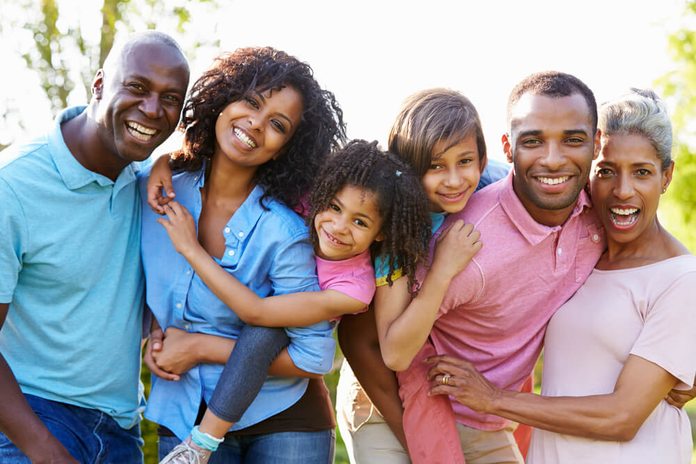 Multigenerational family in bright shirts smiling outside