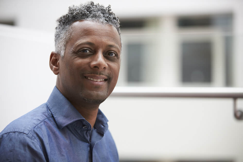 Middle-aged man smiling in blue shirt closeup