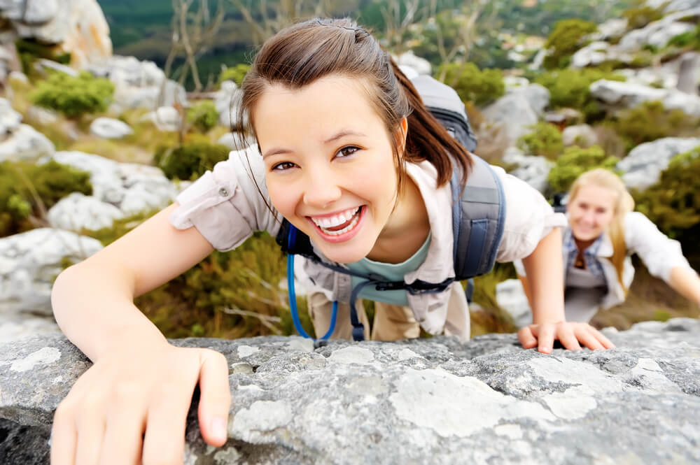 Young woman rock climbing and smiling