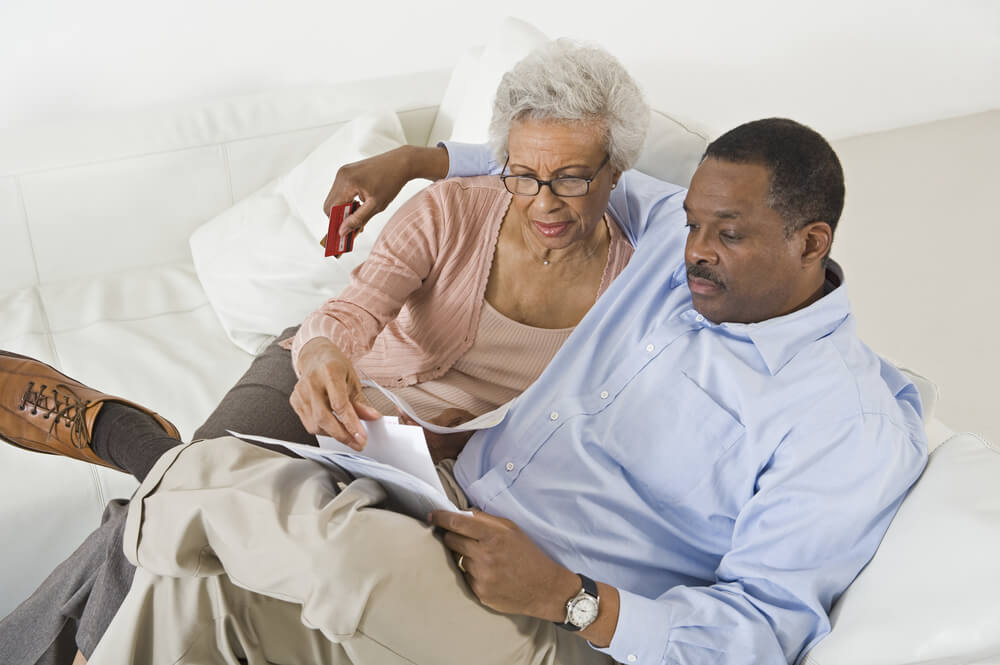 Mother and son reviewing paperwork on a white couch