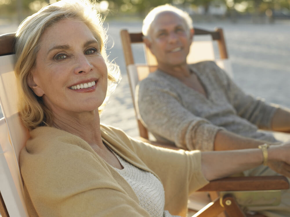 Senior couple, woman in foreground, in deckchairs outside