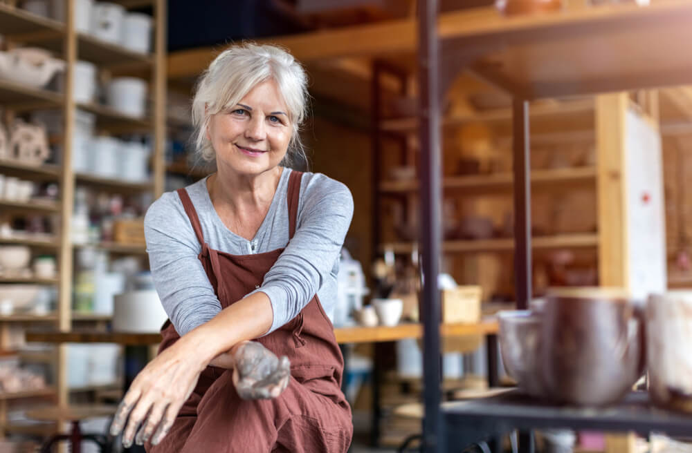 Senior woman taking a break from making pottery in her studio