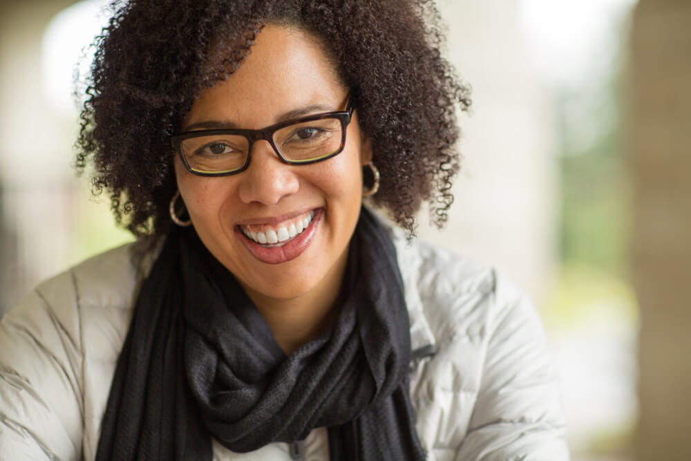 Middle-aged woman in glasses and scarf, smiling